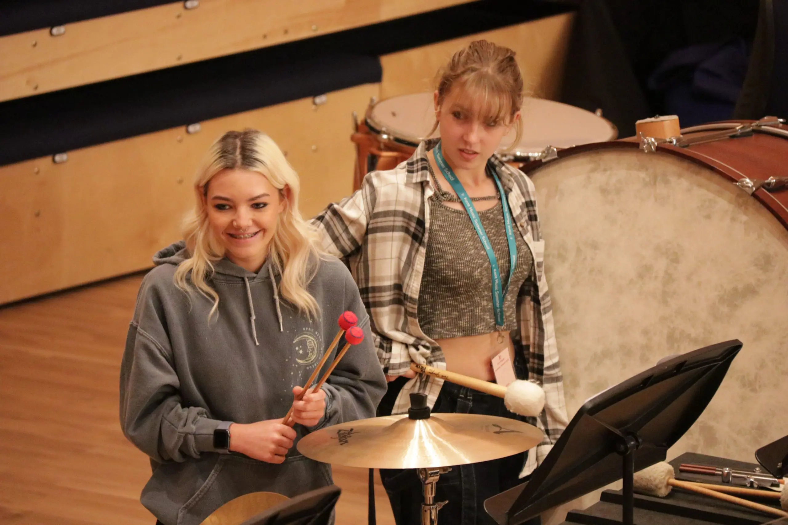 Girls smiling whilst playing percussion at Kent Music Summer School for the Kent County Youth Orchestra