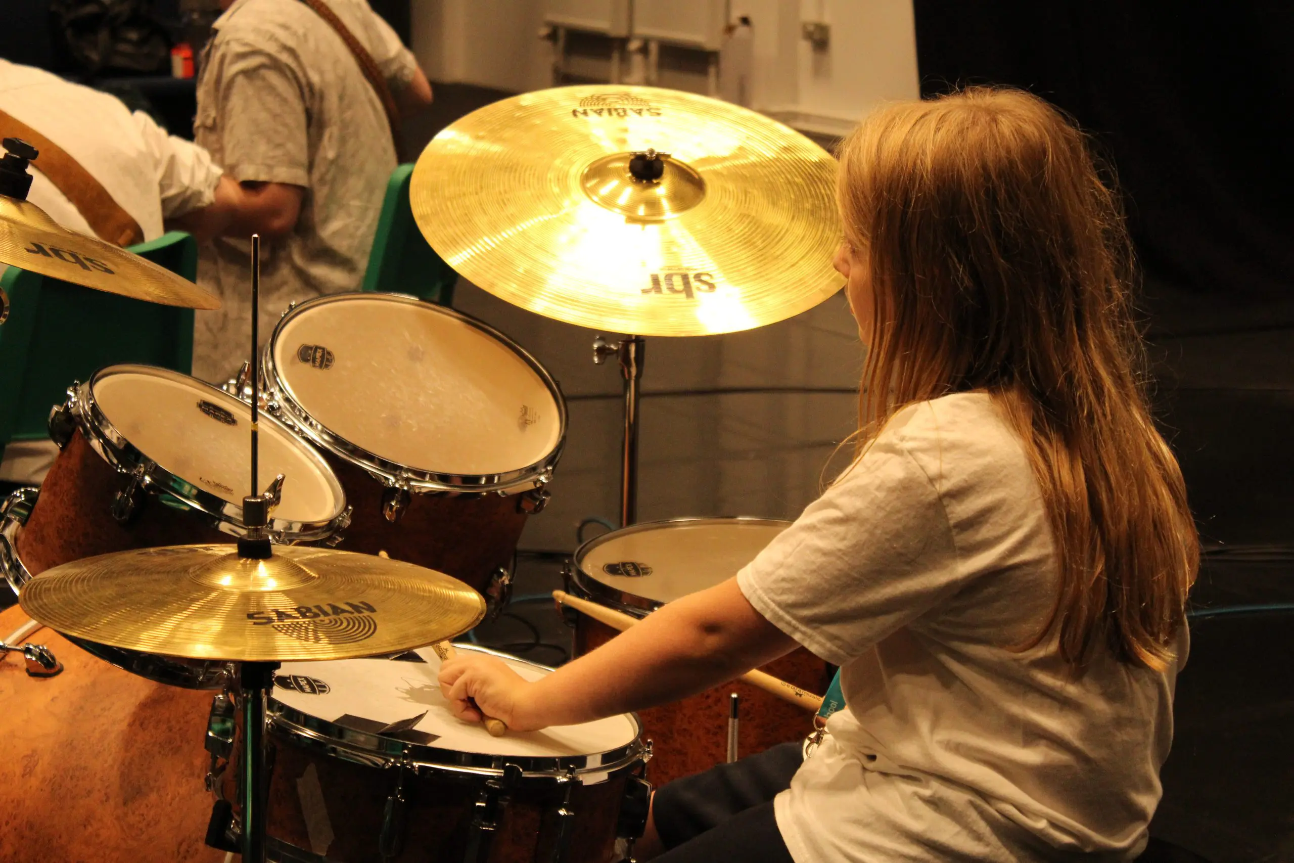 Young girl playing drum kit